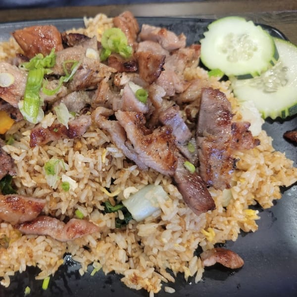 Senzu Noodle Bar's Japanese fried rice with grilled pork, green onions, and cucumber slices.