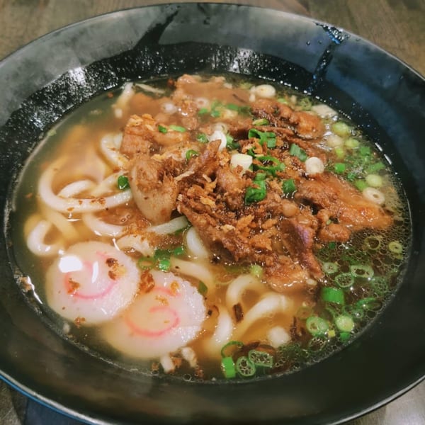 Senzu Noodle Bar's Japanese udon noodle soup with meat, scallions, and fish cakes.